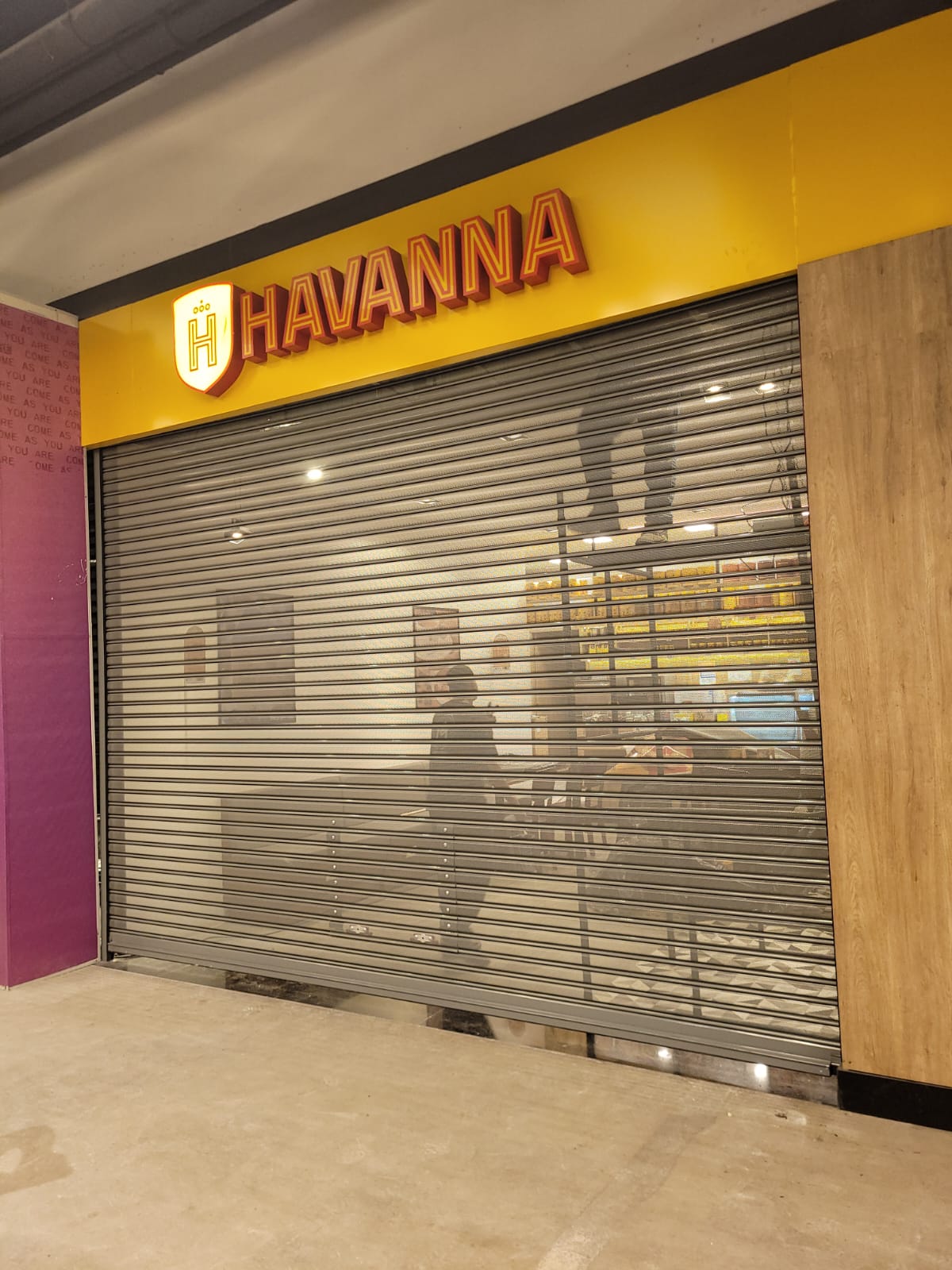 Porta de enrolar telada instalada na loja Havanna em shopping