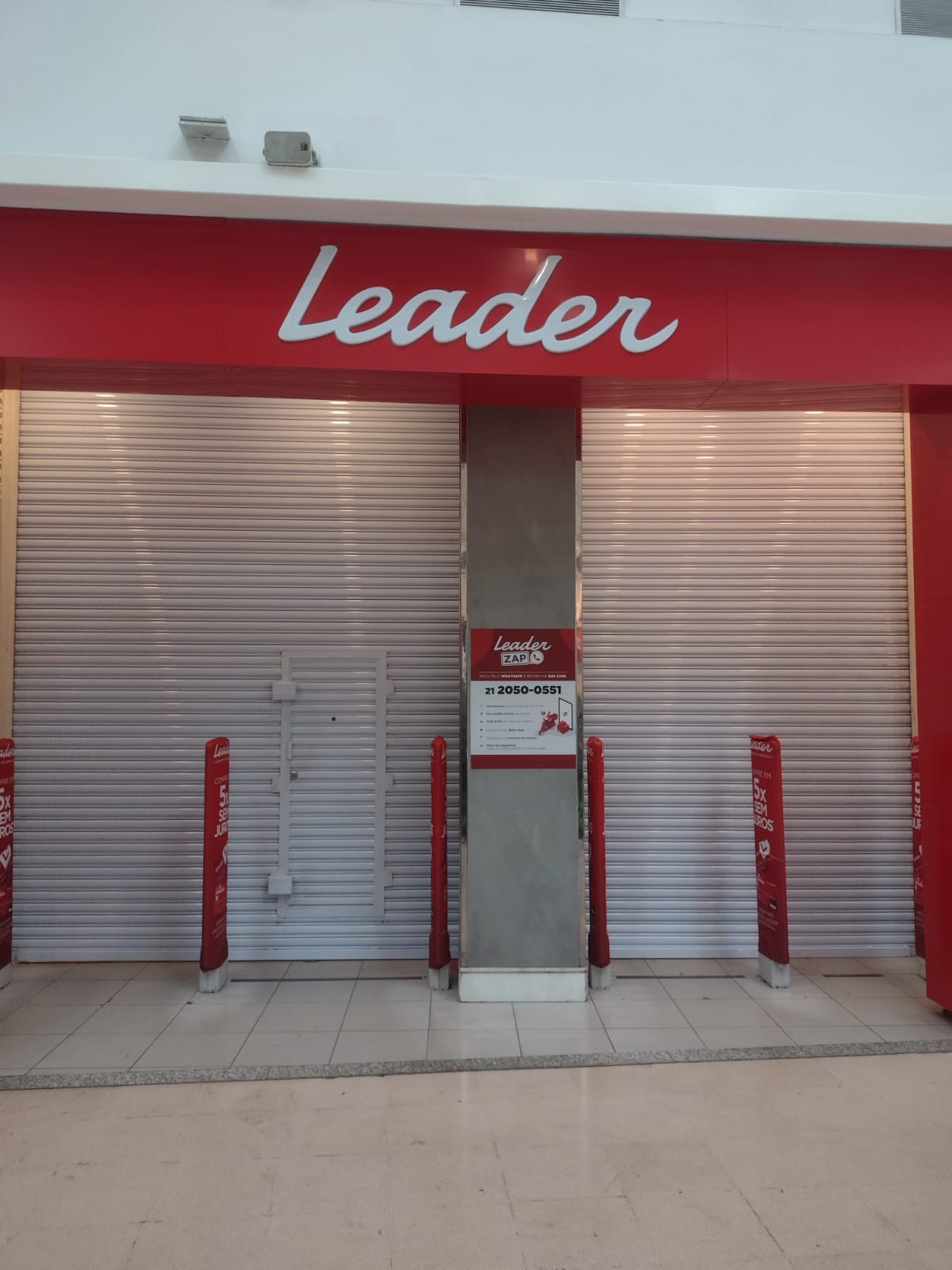 Porta de enrolar fechada na entrada da loja Leader em shopping